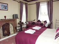 A view of Room 1 - kingsized bedroom with additional day bed