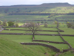 A view looking down over Askrigg and across Wensleydale towards Addlebrough